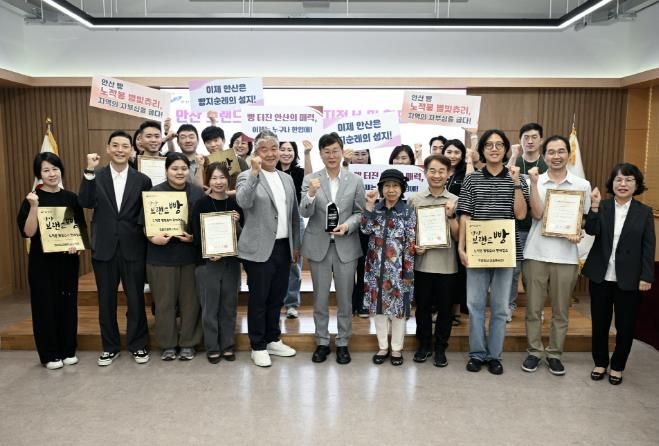 이민근 안산시장이 시청 제1회의실에서 안산 브랜드 빵 ‘노적봉 별빛츄리’ 판매 지정업소 현판 전달식을 진행하고 함께 기념촬영을 하고 있다.