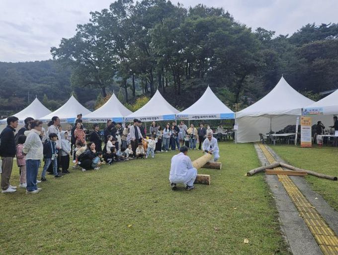 지난 18일, 대목장 송찬의 보유자가 백제전통 문화행사에서 전통목조건축의 부채 과정을 시연하고 있다.