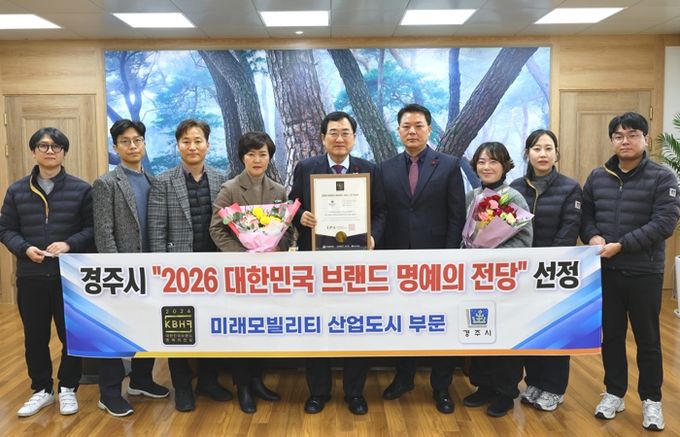 경주시가 ‘2026 대한민국 브랜드 명예의 전당' 미래모빌리티 산업도시 부문에 선정된 가운데, 주낙영 경주시장과 관계자들이 기념촬영을 하고 있다